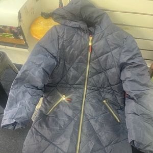 Blue puffer jacket with gold zipper, the pockets also have zipper